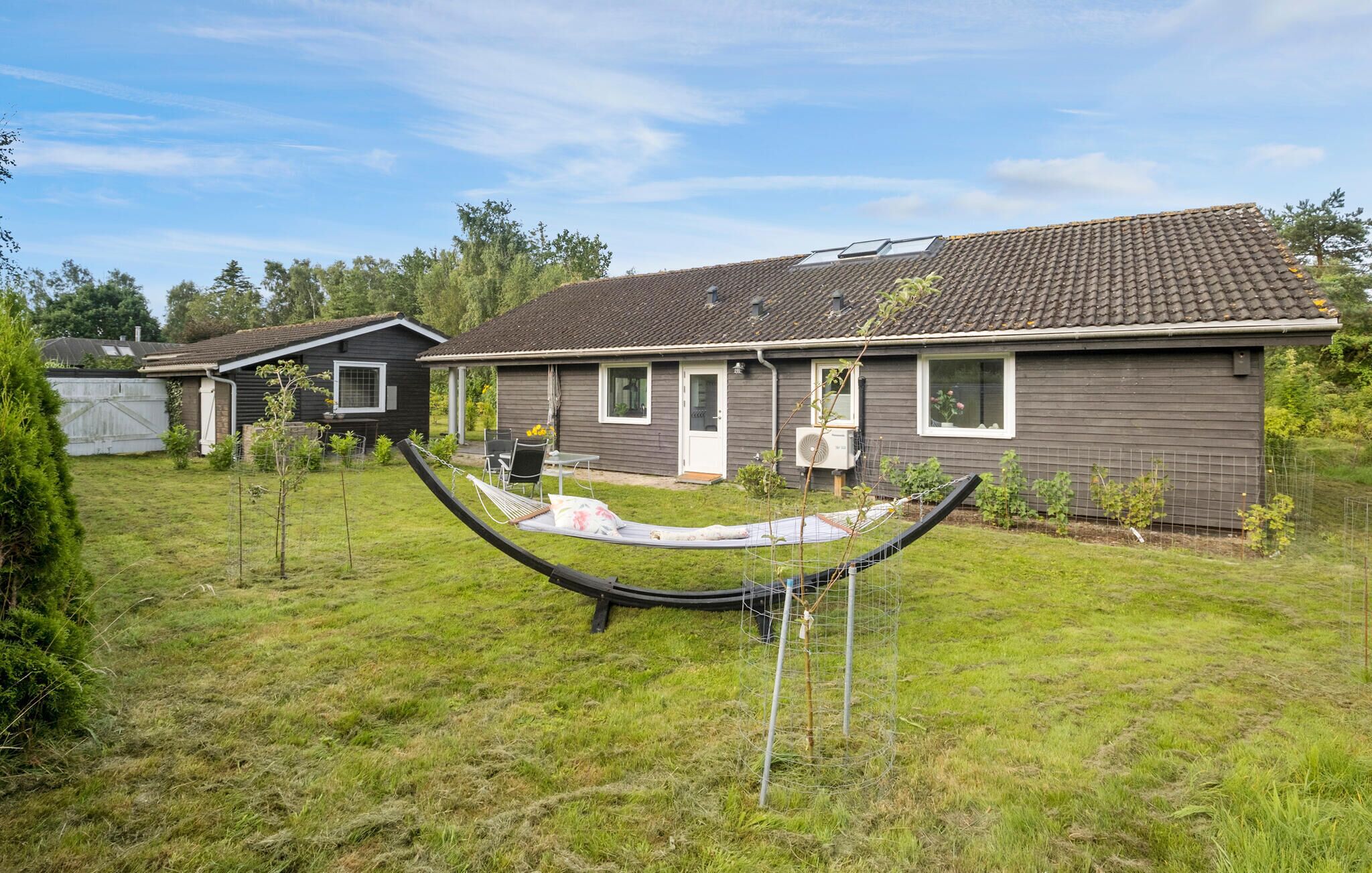 A residential house with a tiled roof, a front door, and a small porch area.
