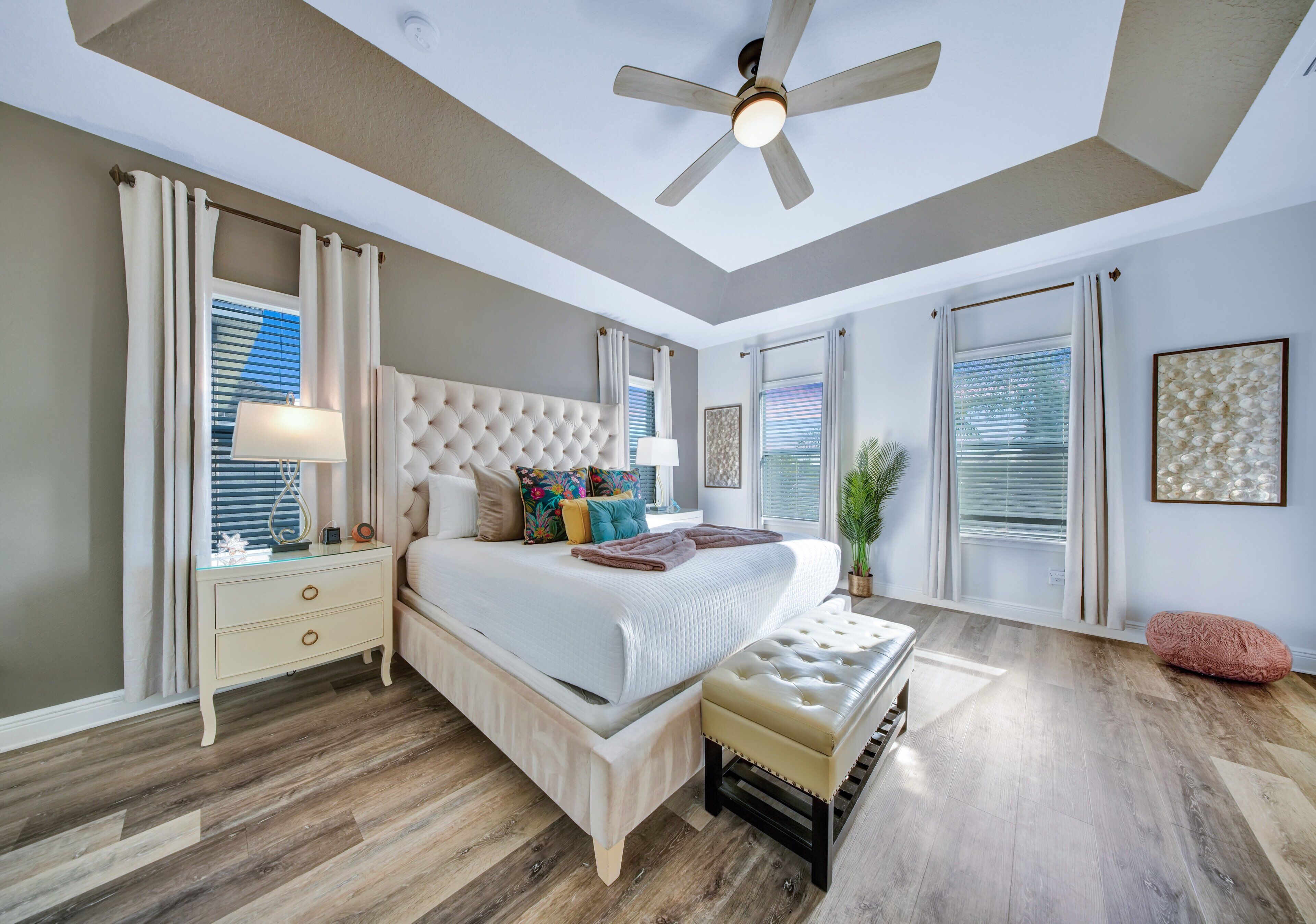A bedroom with a bed, nightstand, and a ceiling fan.