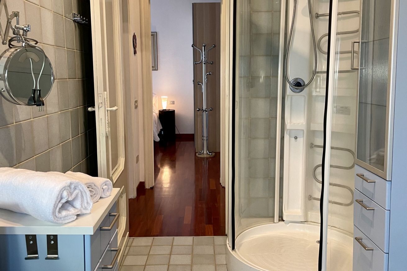 Un baño moderno con ducha acristalada, toallero y espejo.