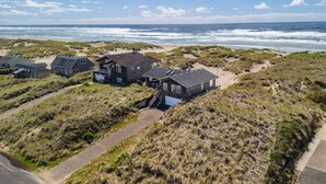 A coastal house complex with multiple buildings, a sandy beach, and ocean views. - Ocean Front with Views! Bridge Views! Sandy Beach! (Waldport)