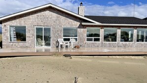 A two-story house with a brick facade, large windows, and a chimney. - Ocean Front with Views! Bridge Views! Sandy Beach! (Waldport)