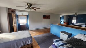 A bedroom with two beds, a ceiling fan, a window with curtains, a dresser, and a wall-mounted mirror. - Snowmobiling & Fourwheelering right out on the main trail (Stewartstown)