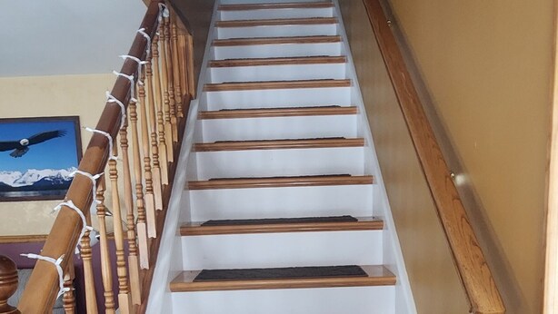 A staircase with wooden steps and a handrail, leading to an upper floor. - Snowmobiling & Fourwheelering right out on the main trail (Stewartstown)