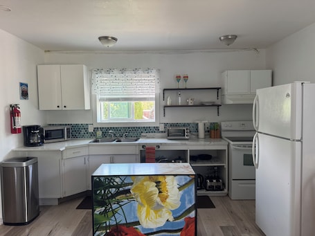 Fridge, microwave, oven, stovetop. Tiny house on an orchard