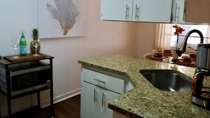 Cocina con encimeras de granito, electrodomésticos de acero inoxidable y muebles de cocina de color claro.