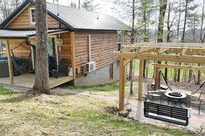 A log cabin with a porch, outdoor seating, and a fire pit. - Alone At Last- Hot tub, Fireplace, Fire pit (Campton)