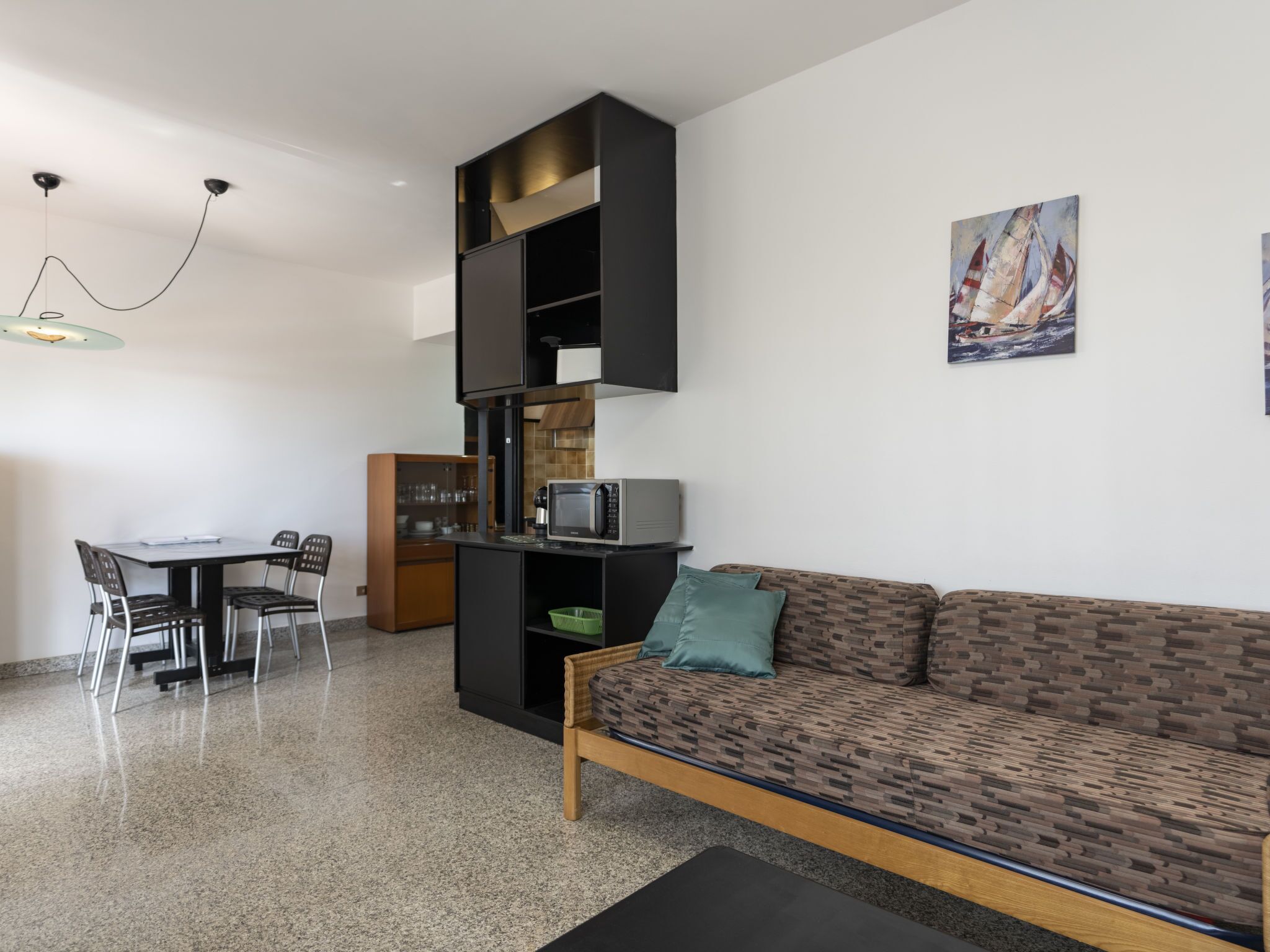 Eine moderne Küche mit Essbereich, einer Couch und Kunstwerken an der Wand.
