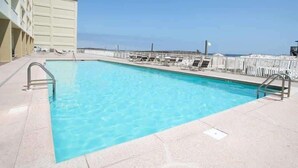 A rectangular pool with clear blue water, surrounded by a concrete deck. - Boardwalk 584 (Gulf Shores)