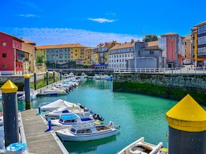 A marina with boats docked along a waterfront, surrounded by colorful buildings.