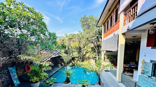Ein Innenhof mit Swimmingpool, Blumentöpfen und einem Boden aus Steinplatten.