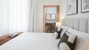 A hotel room with a bed, a desk, a chair, and a large mirror. - GuestReady - Little Johnny Stay (Porto)