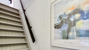 Una escalera con un cuadro abstracto enmarcado en la pared.