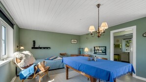 Un comedor con una mesa cubierta con tela azul, sillas de madera y un candelabro.