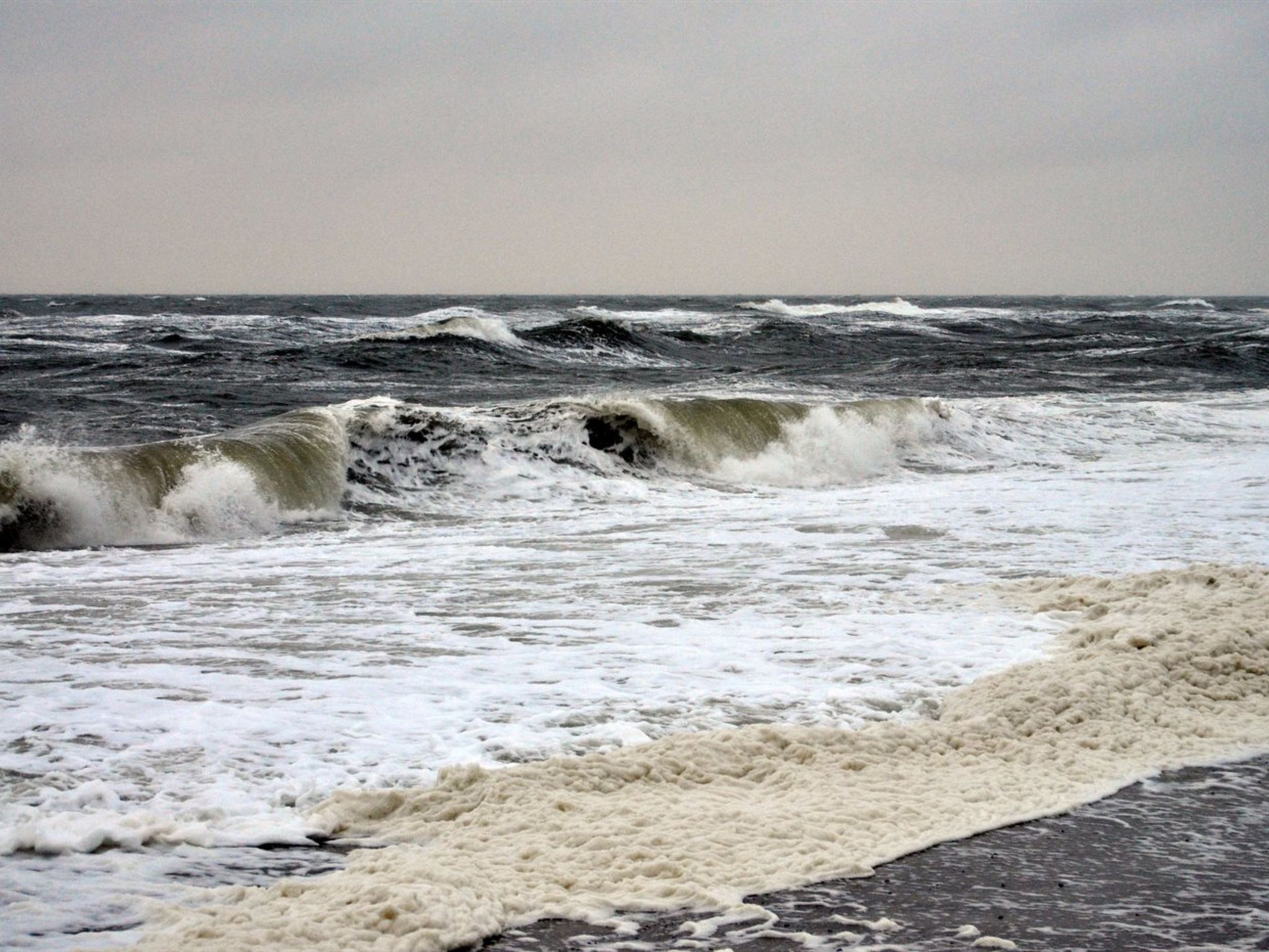 Ein Strand mit brechenden Wellen.