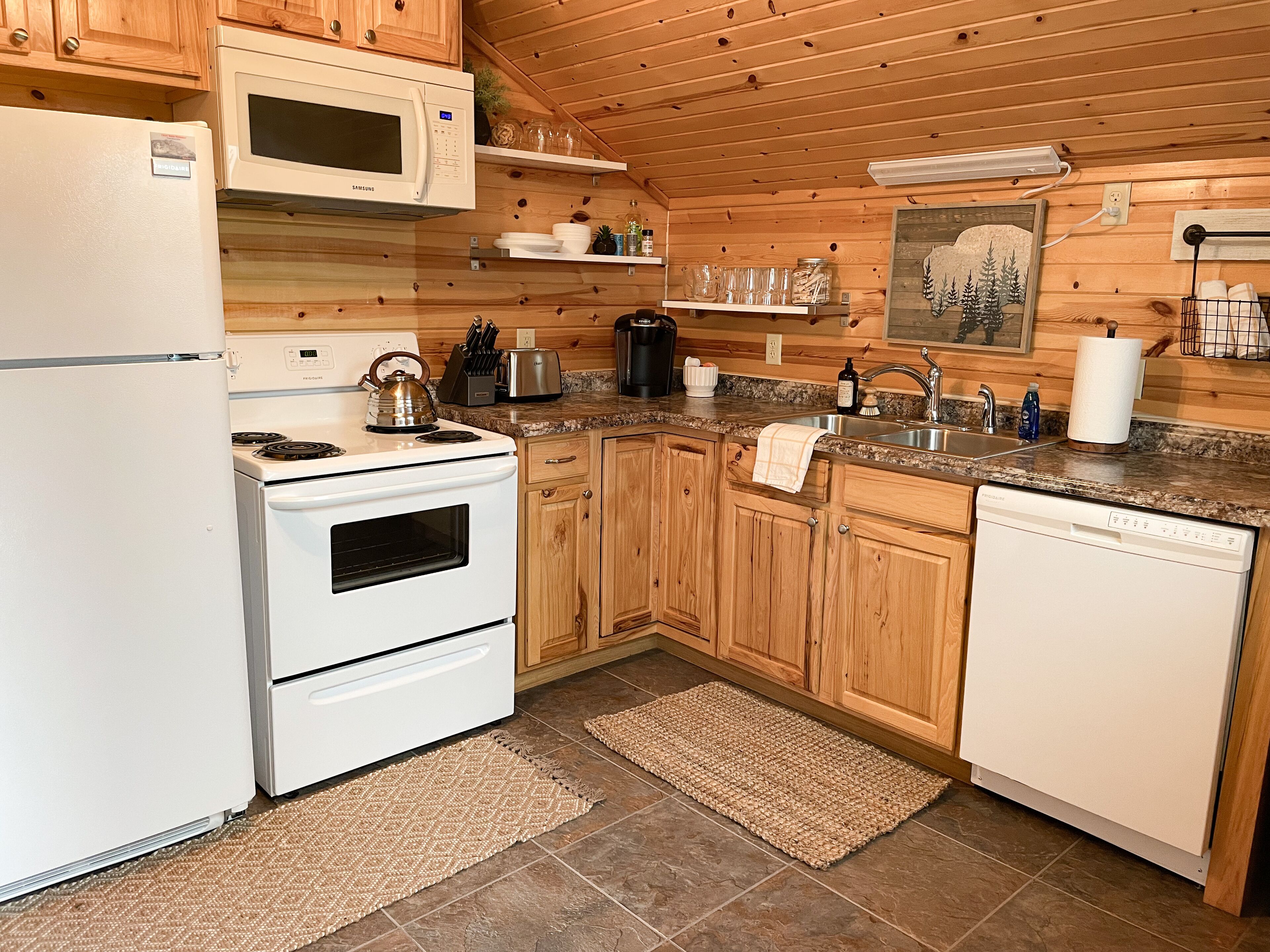 Une cuisine moderne avec des meubles en bois, un four à micro-ondes, une cuisinière et un lave-vaisselle.
