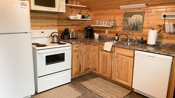 Une cuisine moderne avec des meubles en bois, un four à micro-ondes, une cuisinière et un lave-vaisselle.