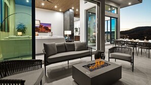 Un salon moderne avec une cheminée, un canapé et un coin repas comprenant des chaises et une table.