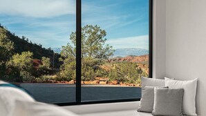 Une chambre dotée d’une grande fenêtre donnant sur un paysage montagneux.