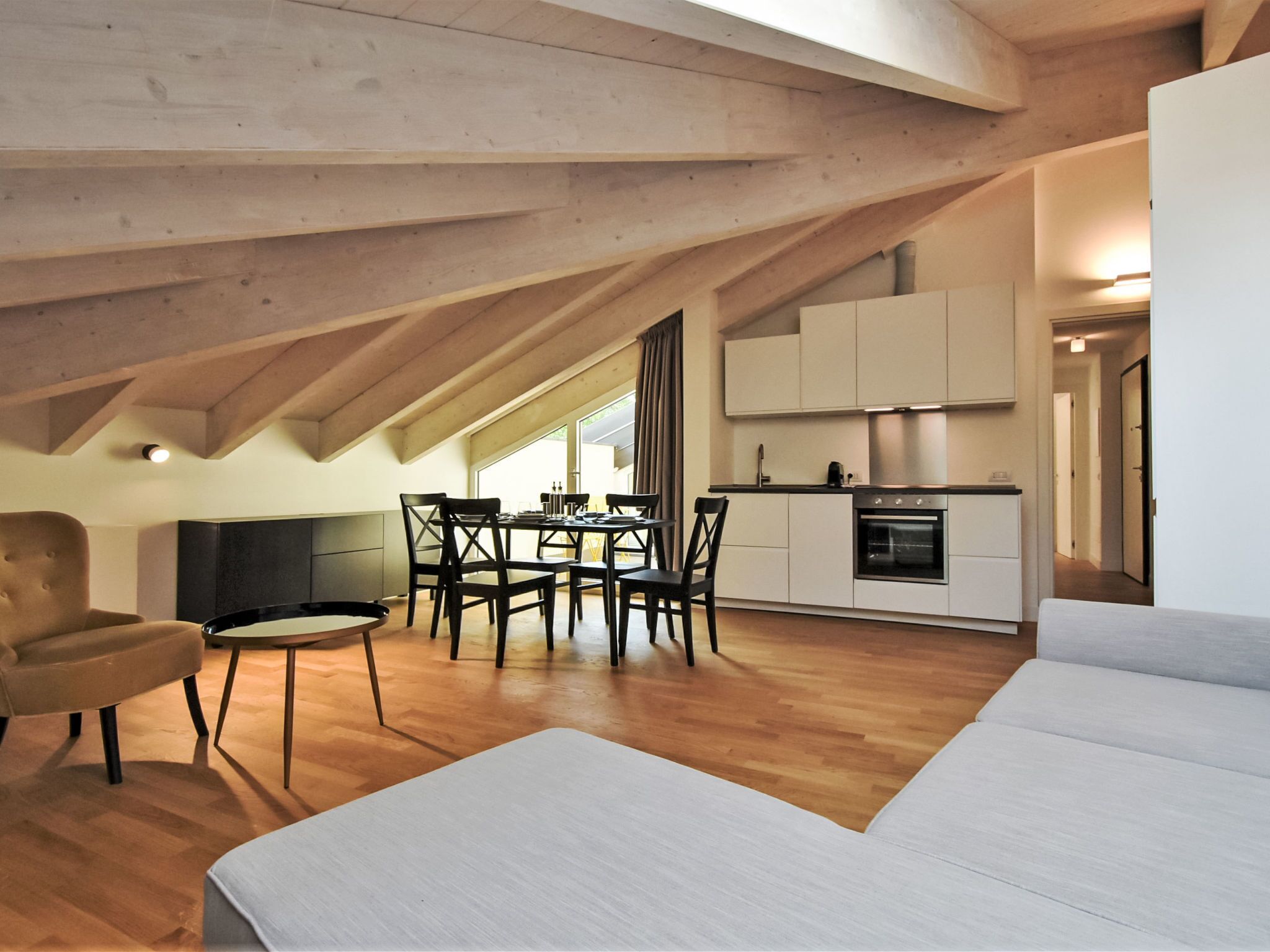 Apartamento loft moderno com área de jantar, cozinha e uma grande janela que proporciona luz natural.