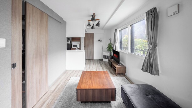 A modern living room with a wooden coffee table, a grey sofa, and a TV on a wooden stand. - SERAPHIC 101 (Chitose)