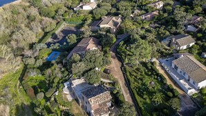 An aerial view of a coastal residential area with houses, a beach, and a tennis court. - Vacation home Paulka by Interhome (Sainte Lucie Porto Vecchio)
