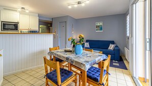 Ein kompakter Wohnbereich mit Essplatz, Küchenzeile und Sofa.