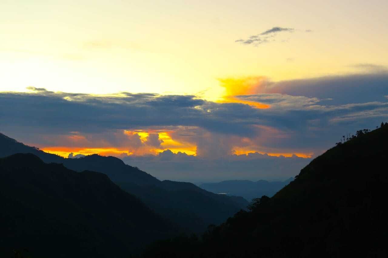 A mountainous landscape during sunset with a clear sky and no visible structures.