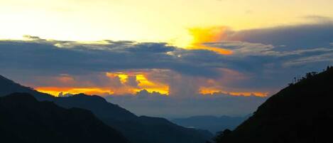 A mountainous landscape during sunset with a clear sky and no visible structures.