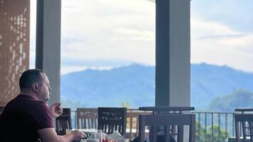 A man dining at a table with a mountain view.