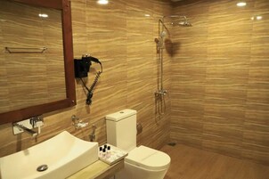 Baño con lavamanos, inodoro y ducha.