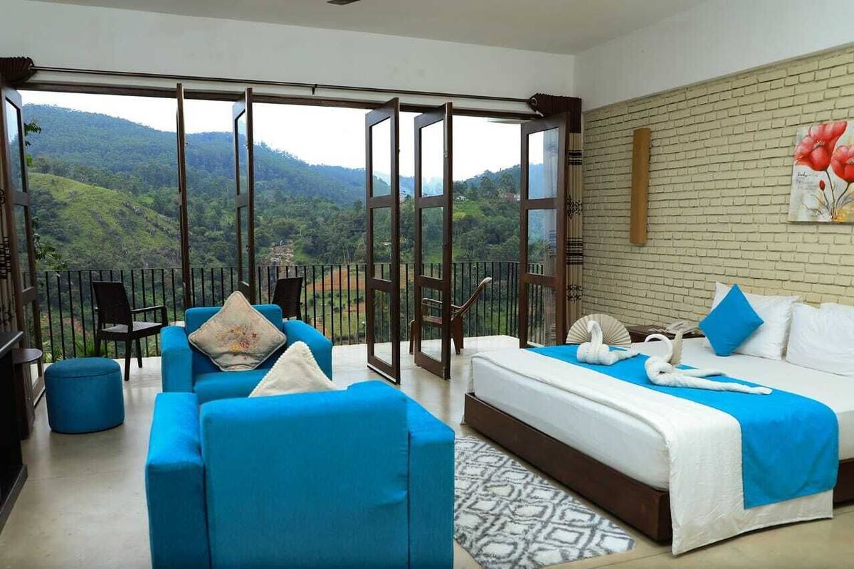Ein Hotelzimmer mit Balkon, einem Bett, einer Couch und einem Tisch.