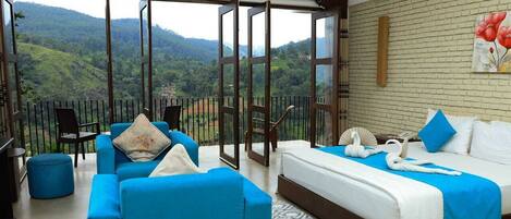 Habitación de hotel con balcón, cama, sofá y una mesa.