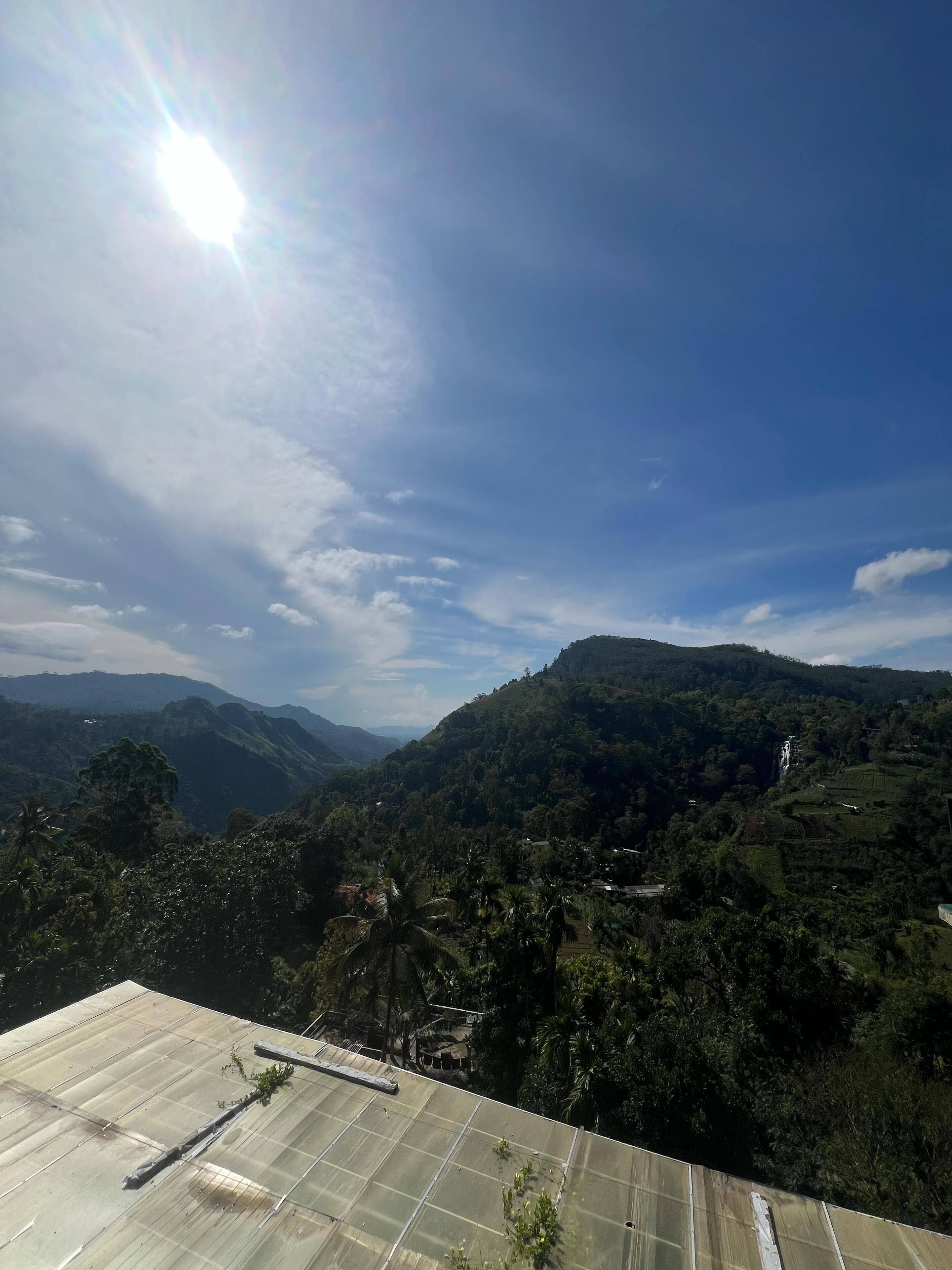 A view of a mountainous landscape with a clear sky and a distant waterfall.