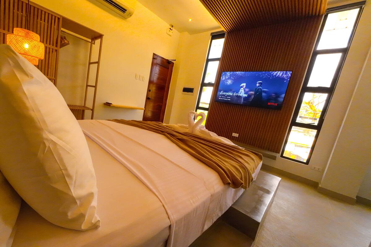 Ein Hotelzimmer mit einem Bett, einem Fernseher und einem Fenster.