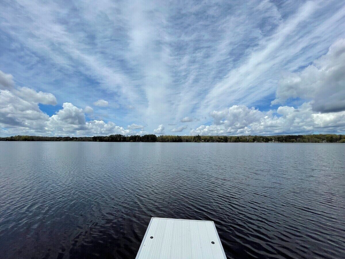 A calm lake with a wooden dock extending into the water.