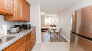 A modern kitchen with wooden cabinets, a granite countertop, and stainless steel appliances. - Sojourns Spit 2 BR  Beach Shack 1278WOV#2 (Norfolk)