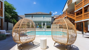 A poolside area with wicker chairs and a white bollard. - Newly Renovated Atlanta Condo Prime Buckhead, Atl (Atlanta)