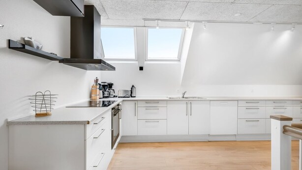 A modern kitchen with white cabinets, a black range hood, and a skylight. - "Nafne" - 1.2km from the sea by Interhome (Hvide Sande)