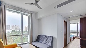 Ein modernes Wohnzimmer mit einer Couch, einem kleinen Tisch und einem Deckenventilator.