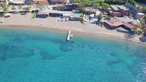 An aerial view of a coastal area with clear turquoise waters, a pier, and buildings with a mix of architectural styles. - Sant'Anna Volterraio - Maestra 56 - Sant'Anna del Volterraio - Maestra 56 (Rio dell'Elba)