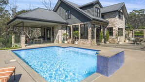 A two-story house with a swimming pool, stone exterior, and large windows. - Bellmohr House on the Lake (Wentworth Falls)