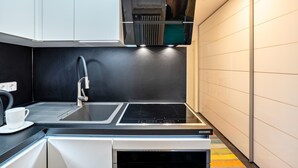 Une cuisine moderne équipée d’une cuisinière intégrée, d’un évier et d’une machine à café.