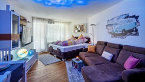 Une chambre moderne avec un lit, un canapé, un bureau et un plafond doté d’un système d’éclairage décoratif.