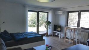 Une chambre moderne équipée d’un lit, d’une télévision, d’une table à manger et d’une plante en pot.