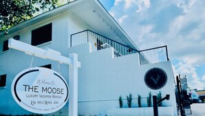 A modern building with a sign reading "The Moose Luxury Vacation Rentals" with a moose logo. - Luxe Modern loft w/ King Bed, Free Parking & Wi-Fi (Memphis)
