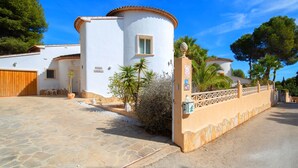 A white villa with a tiled roof, a stone driveway, and a gated entrance. - Vacation home Angela by Interhome (Benissa)