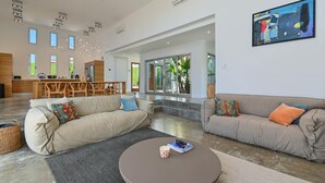 A spacious living area with two sofas, a coffee table, and a dining area with a wooden table and chairs.