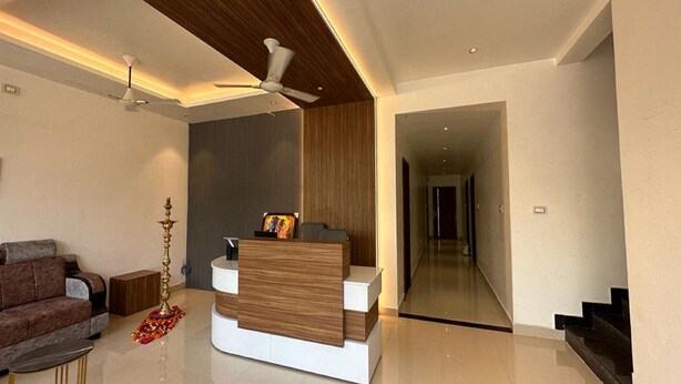 Una sala moderna con un sofá, una mesa de centro, una lámpara decorativa y una pared de madera como elemento decorativo.