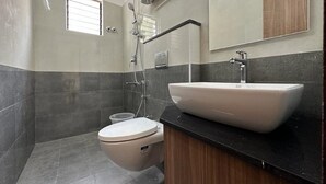 Un baño moderno con inodoro, lavabo y ducha.