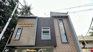 Un edificio de dos pisos con un letrero que dice 'Sri Krishna Residency'.